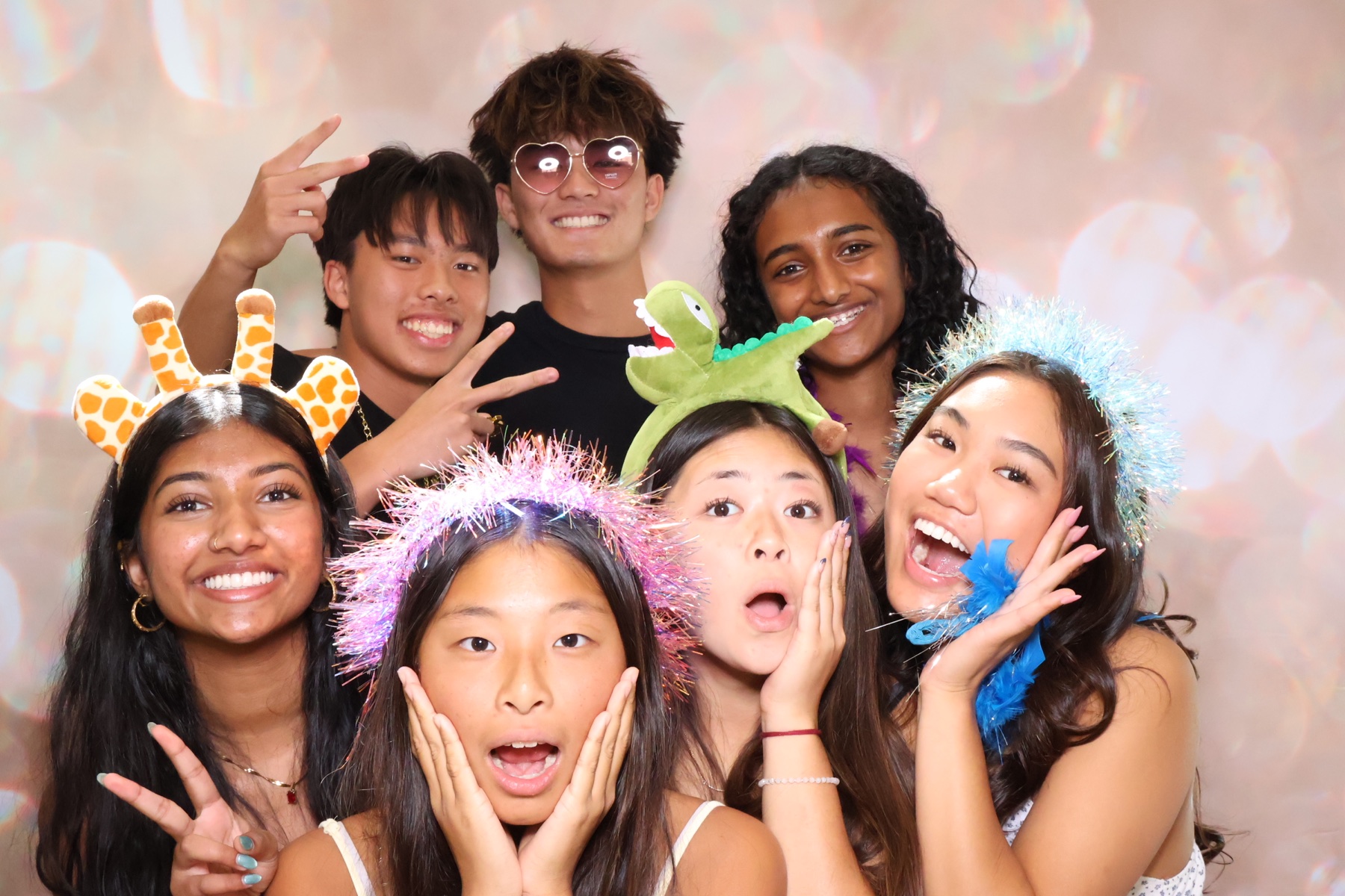 Friends laughing together with colorful photo booth props